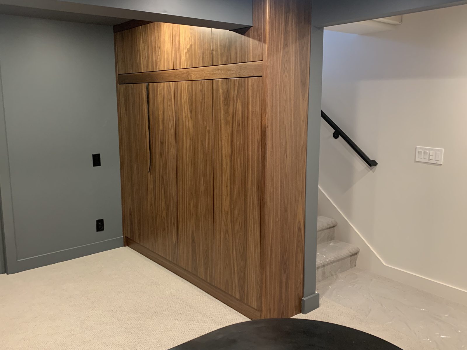 Closed wood Murphy bed beside stairs