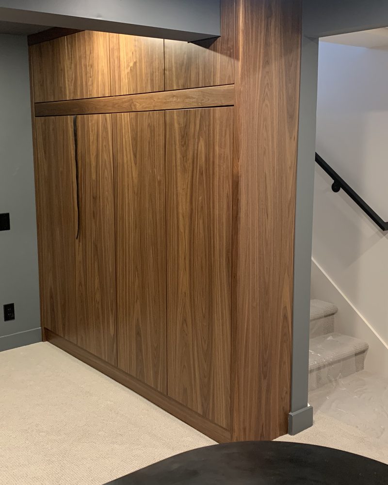 Closed wood Murphy bed beside a staircase