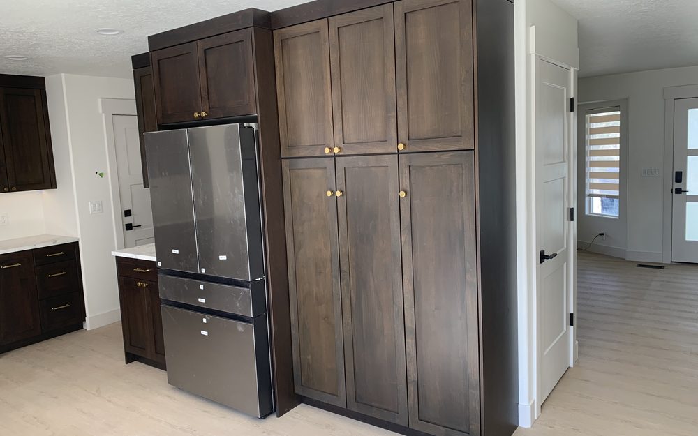 Floor-to-ceiling wood cabinet installation beside a kitchen
