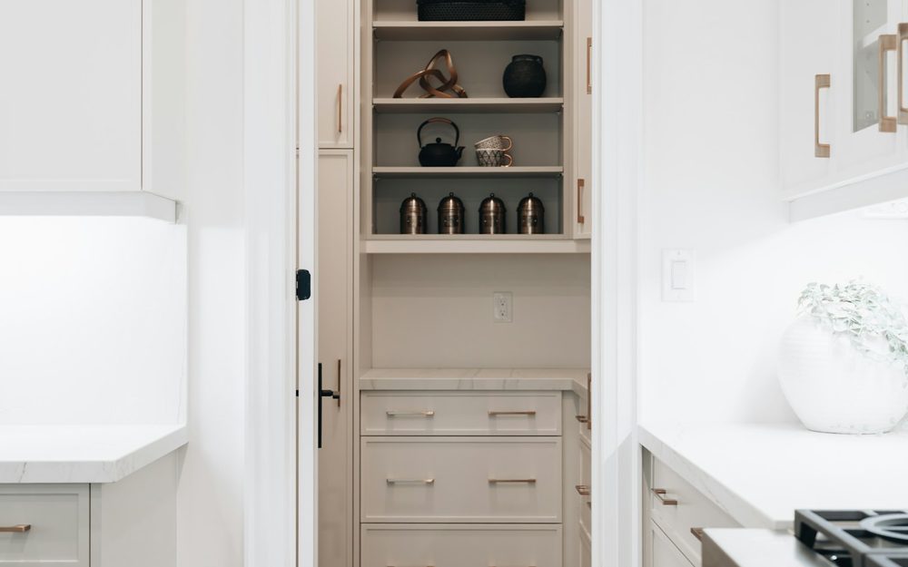 White pantry cabinetry with open shelves and lower drawers