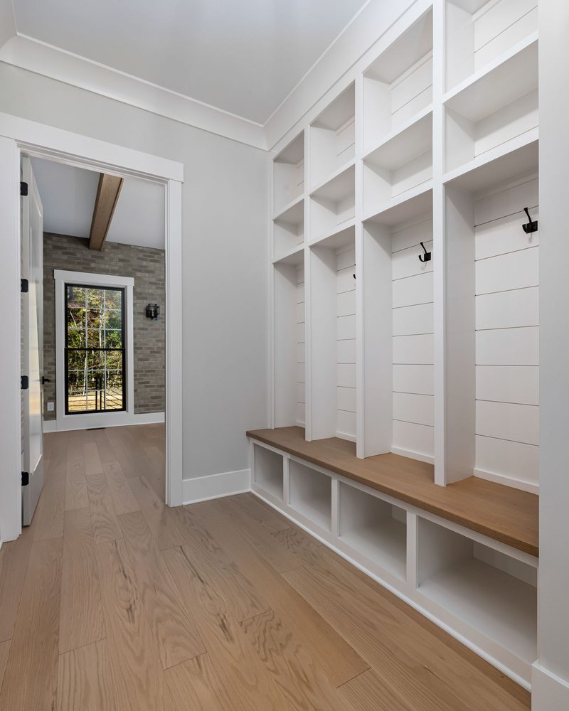 White entryway cubbies, hooks, and bench storage
