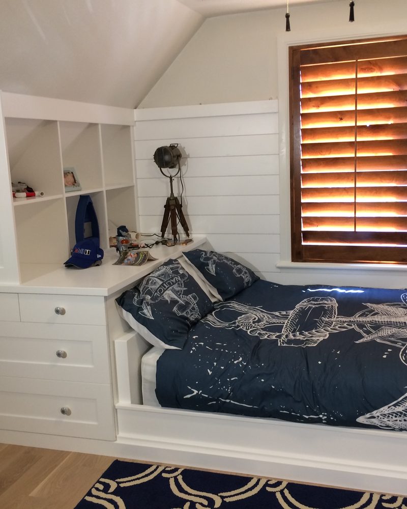 White built-in cabinets and drawers beneath a window